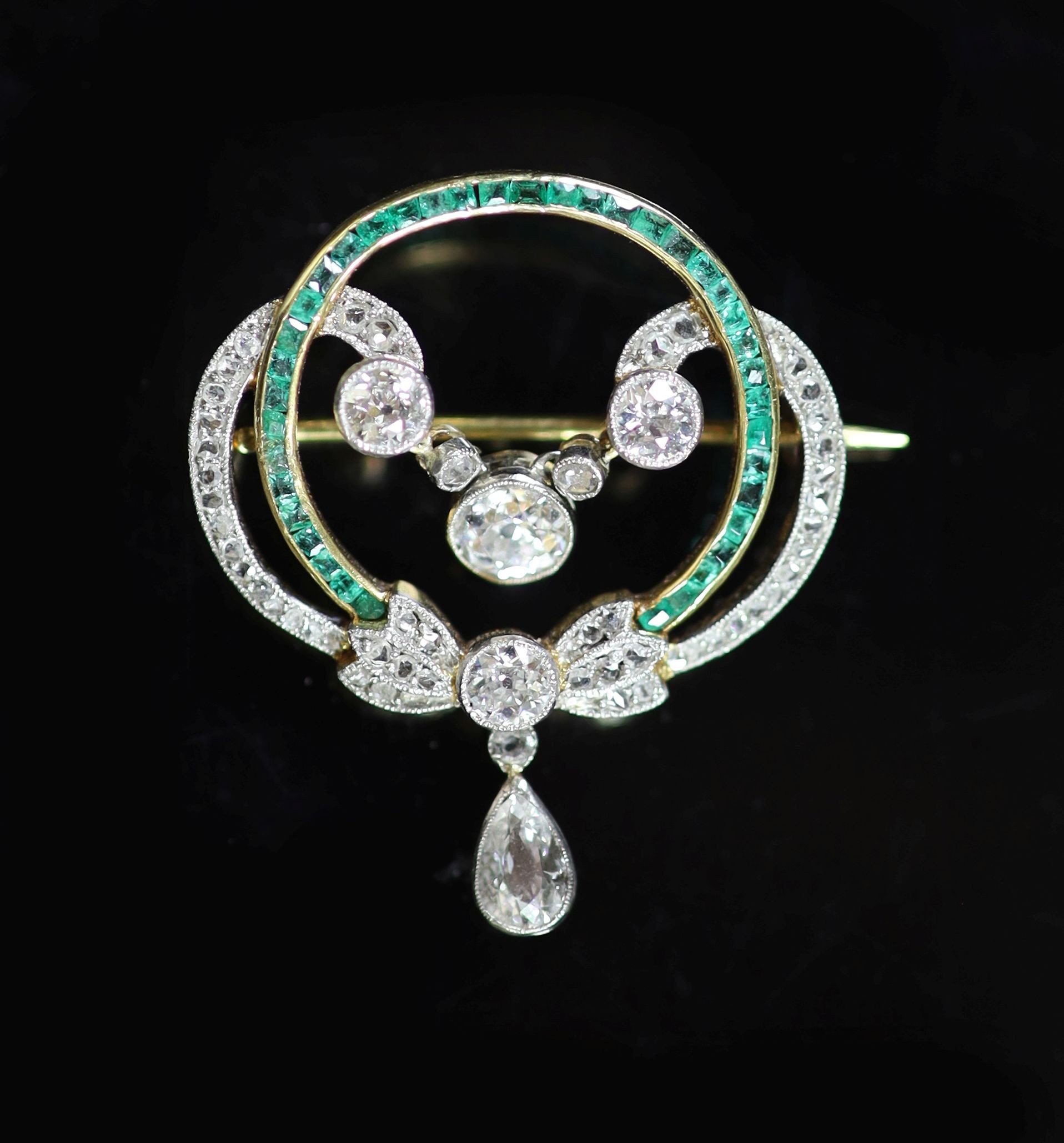 A 1920's gold and platinum, emerald and diamond set open work drop brooch